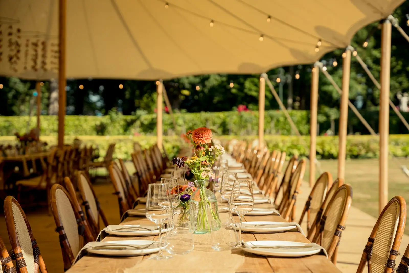 Recepção de evento em tenda com mesa posta para convidados